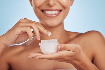 Image showing Beauty, lotion and woman with skincare product for cosmetic hydration isolated in a studio blue background. Cream, moisturizer and happy female person with a jar of dermatology creme for healthy skin