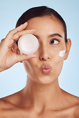 Image showing Portrait, beauty and woman with cream, dermatology and skincare on a blue studio background. Face, female person and model with lotion, cosmetics and wellness with creme, pouting and luxury product