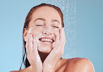 Image showing Happy woman, cleaning face and soap for beauty, shower and hygiene with grooming on blue background. Female model, sustainability and water drop with facial, dermatology and skincare in studio