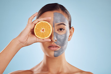 Image showing Portrait, orange and mask for beauty with a woman in studio on a blue background for antiaging skincare. Face, facial and fruit with an attractive young female holding citrus for natural treatment