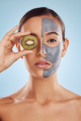 Image showing Portrait, kiwi and mask for skincare with a woman in studio on a blue background for antiaging beauty. Face, facial and fruit with an attractive young female holding a berry for organic treatment