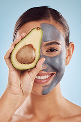 Image showing Woman, avocado and face mask for natural skincare, beauty and vitamin d benefits on studio blue background. Portrait of person or model in charcoal facial, green fruits and skin care for dermatology