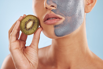 Image showing Fruit, face mask and woman with kiwi for organic skincare or cosmetic treatment isolated in a blue studio background. Skin, beauty and young female person with facial wellness, nutrition and detox