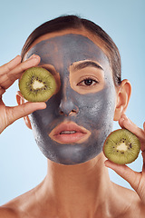 Image showing Portrait, face mask and kiwi with beauty and woman, skincare and eco friendly product on blue background. Charcoal facial, fruit and vegan treatment, female model with skin detox and dermatology