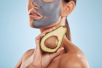 Image showing Woman, avocado and face mask for skincare, natural beauty and vitamin d benefits on studio, blue background. Person or model with charcoal facial, green fruits and healthy skin care for dermatology