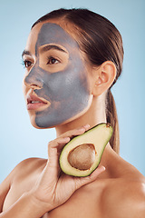 Image showing Vision, avocado and mask for beauty with a woman in studio on a blue background for antiaging skincare. Face, facial and detox with an attractive young female holding a fruit for natural treatment