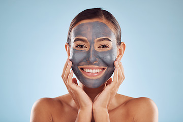 Image showing Woman, charcoal and face mask for skincare, beauty and natural cosmetics cleaning product on studio, blue background. Portrait of person or model in facial collagen and mud skin care for dermatology