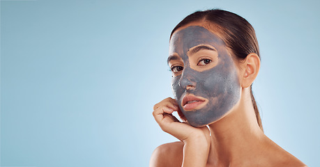 Image showing Face mask, skincare and woman with beauty, mockup and girl on a blue studio background. Portrait, female person or model with cosmetics, charcoal or aesthetic with dermatology, hydration or self care