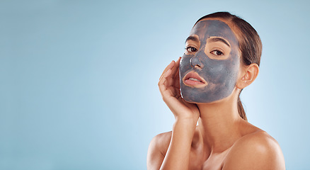 Image showing Charcoal face mask, skincare and woman with beauty in studio on banner or blue background mockup space. Cosmetics, serious model and portrait in facial treatment for peeling, dermatology or cleaning