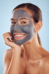 Image showing Woman facial portrait and charcoal mask for beauty, skincare and natural cosmetics cleaning product on studio, blue background. Happy person or model in face collagen and mud skin care in dermatology