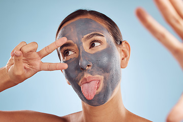 Image showing Skincare, face mask and selfie of woman for beauty, cosmetics or charcoal, clay facial for skin care on studio background. Funny, emoji pose and girl with hand, peace sign and dermatology or spa