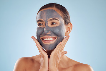 Image showing Woman, charcoal face mask and thinking of skincare, natural beauty and cosmetics benefits on studio, blue background. Happy person or model with facial collagen and healthy skin care for dermatology