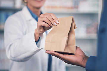 Image showing Woman, pharmacist and hands with medication for patient, healthcare or paper bag at the pharmacy. Closeup of female person or medical professional giving pills, drugs or pharmaceuticals to customer