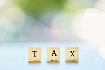 Image showing Tax, word or message on wood blocks or letters writing on financial, report or management of money on a bokeh background space. Accounting mockup, planning for finance or taxes on audit in the future