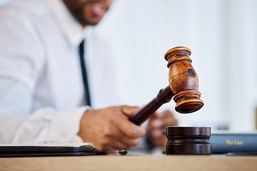 Image showing Hand, gavel and a man judge in court for order at a verdict in a criminal case or trial closeup. Justice, law or legal with a magistrate hammer in a courtroom for a hearing of evidence or legislation