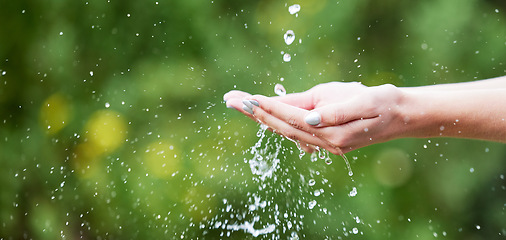 Image showing Woman, hands and palm with water for natural sustainability, washing or cleanse in nature. Closeup of female person with falling liquid drops for sustainable eco friendly environment in the outdoors