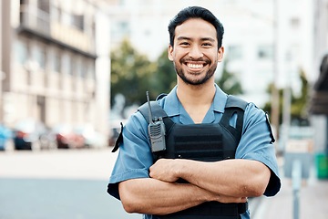 Image showing Portrait, happy or policeman in city with arms crossed for law enforcement, surveillance or street safety. Confident cop, smile or proud Asian security guard on patrol in town for crime or justice