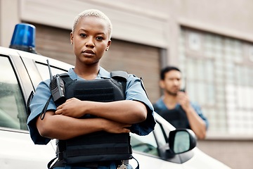 Image showing Black woman, police and arms crossed in city for law enforcement protection or street safety. Portrait of serious African female person, security guard or cop ready for justice or crime in urban town