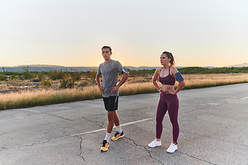 Image showing A handsome young couple running together during the early morning hours, with the mesmerizing sunrise casting a warm glow, symbolizing their shared love and vitality