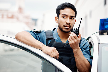 Image showing Asian man, police and walkie talkie for radio in city communication, reinforcement or emergency. Serious male person or security guard by cop car and calling backup for crime on patrol in urban town