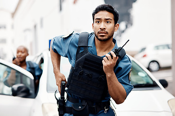 Image showing Asian man, police and walkie talkie with gun in city for suspect, communication or reinforcements. Serious male person, security guard or cop radio calling backup for crime in street of an urban town