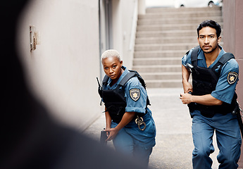 Image showing Police, crime and team in the city for protection, justice and law enforcement mission. Serious, collaboration and young woman and man security officers working with guns together in an urban town.