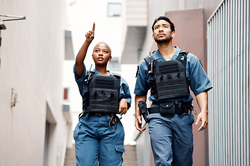 Image showing Teamwork, crime and police in the city for justice, protection and law enforcement mission. Serious, collaboration and young woman and man security officers working with guns together in urban town.