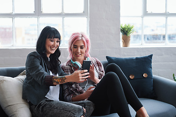 Image showing Phone, social media and students with women friends sitting on a sofa in the campus breakroom at college. Education, university and young female pupils reading a text message while on break to relax
