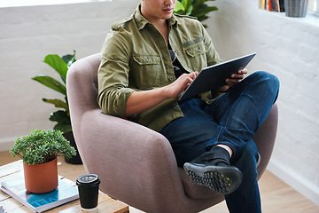 Image showing Working from home, man with chair and tablet, relax in living room with internet search and coffee. Networking, reading website and freelancer with digital app for remote work in social media job.