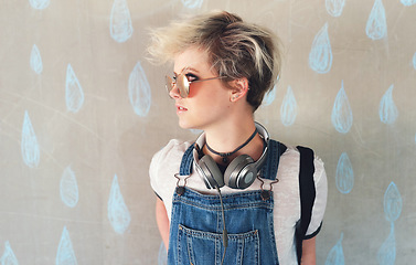 Image showing Fashion, music and a gen z woman thinking in studio on a rain wallpaper background for trendy style. Cyberpunk, idea and headphones with an attractive young female person looking cool or edgy