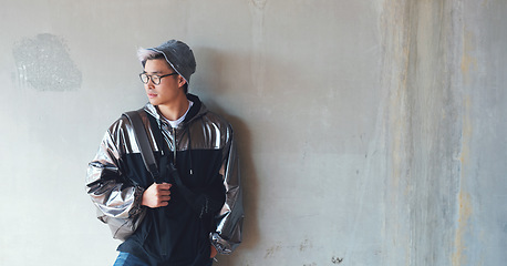 Image showing Fashion, student and gen z asian male streetwear, style and cool clothes on wall background, confident and chilling. Travel, fashionable and Japanese guy outdoors casual, contemporary and stylish