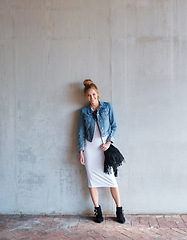 Image showing Portrait, travel and smile with a woman on a concrete wall as a tourist leaning against a building in the city. Fashion, tourism or travelling with a happy and trendy young person in Norway for style