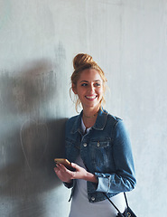 Image showing Phone, thinking and smile with a woman student leaning against a gray wall on the campus of her university. Education, idea and mobile with a happy young female pupil standing at college for learning