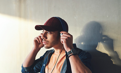 Image showing Man, student with headphones and music on campus, future mindset and audio against wall background. Gen z, education and male person thinking while at college, tech with radio and podcast streaming