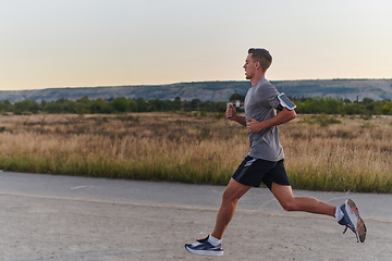 Image showing A young handsome man running in the early morning hours, driven by his commitment to health and fitness