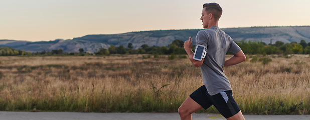 Image showing A young handsome man running in the early morning hours, driven by his commitment to health and fitness