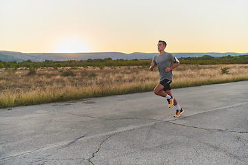 Image showing A young handsome man running in the early morning hours, driven by his commitment to health and fitness