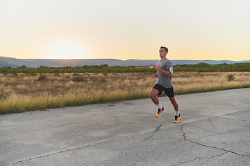 Image showing A young handsome man running in the early morning hours, driven by his commitment to health and fitness