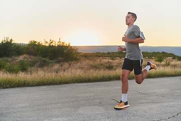 Image showing A young handsome man running in the early morning hours, driven by his commitment to health and fitness