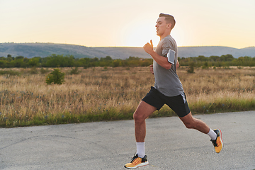 Image showing A young handsome man running in the early morning hours, driven by his commitment to health and fitness