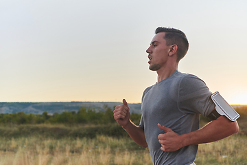 Image showing A young handsome man running in the early morning hours, driven by his commitment to health and fitness