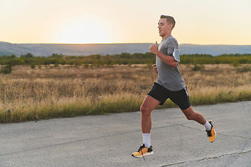 Image showing A young handsome man running in the early morning hours, driven by his commitment to health and fitness