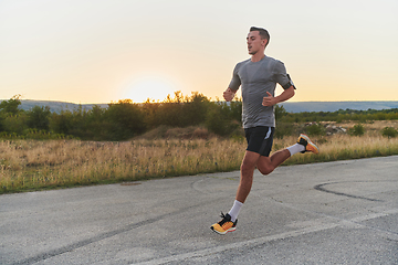 Image showing A young handsome man running in the early morning hours, driven by his commitment to health and fitness