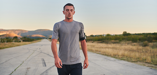 Image showing A young handsome man running in the early morning hours, driven by his commitment to health and fitness