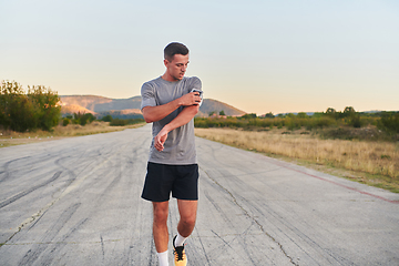 Image showing A young handsome man running in the early morning hours, driven by his commitment to health and fitness