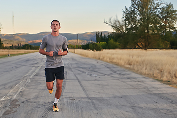 Image showing A young handsome man running in the early morning hours, driven by his commitment to health and fitness