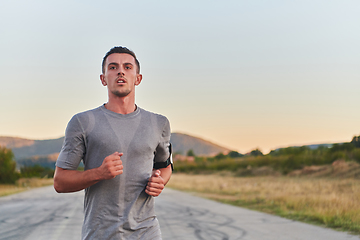 Image showing A young handsome man running in the early morning hours, driven by his commitment to health and fitness