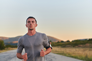 Image showing A young handsome man running in the early morning hours, driven by his commitment to health and fitness