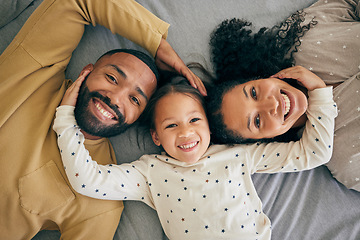 Image showing Happy family, top view and child relax or happy with parents together in the morning laughing in a bedroom on a bed. Smile, mom and dad enjoy quality time with kid with happiness, bonding and love