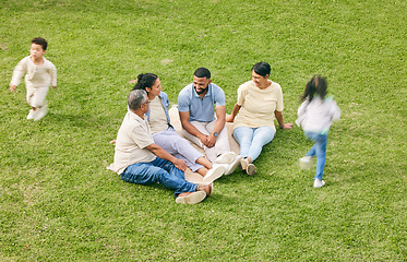 Image showing Family, generations and children running on lawn, travel and vacation with parents and grandparents on grass. People outdoor, men and women relax while kids play with adventure and bonding together